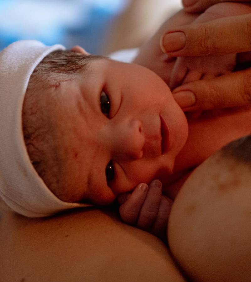 Bebê recém-nascido aconchegado no colo da mãe